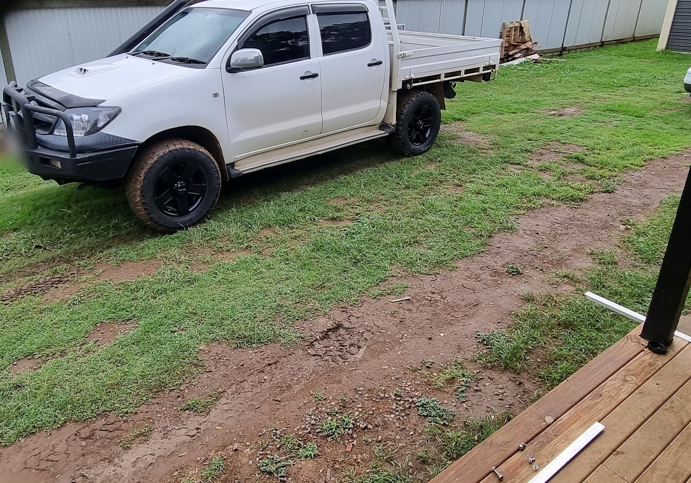 White Toyota Hilux tray back with a bullbar parked on the grass