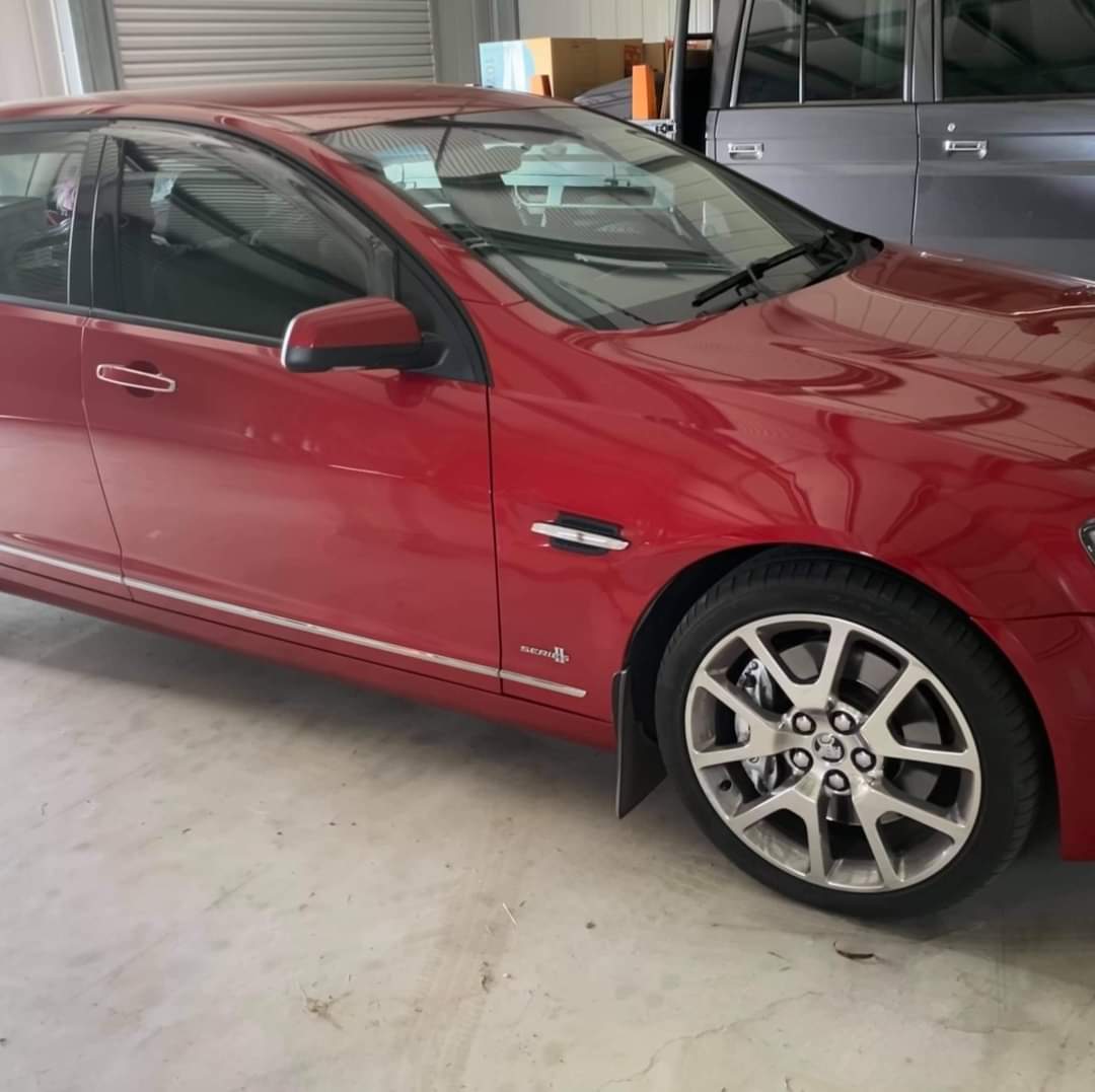 Red Holden Commodore parked inside the workshop shed